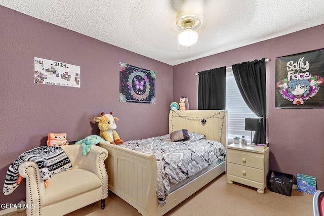 bedroom with ceiling fan, carpet, and a textured ceiling