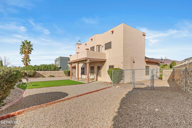 back of house with a balcony and a patio