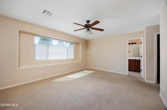 spare room with ceiling fan and light carpet