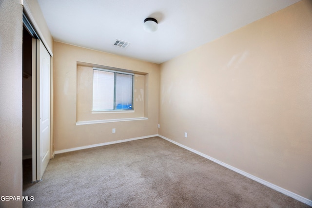 unfurnished bedroom featuring a closet and light carpet