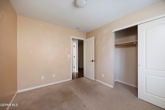 unfurnished bedroom featuring light carpet and a closet