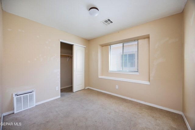 unfurnished bedroom with a closet and light carpet