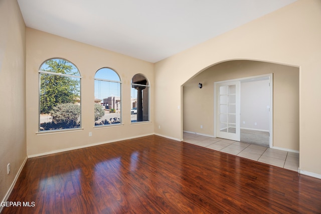 unfurnished room with french doors and light hardwood / wood-style flooring