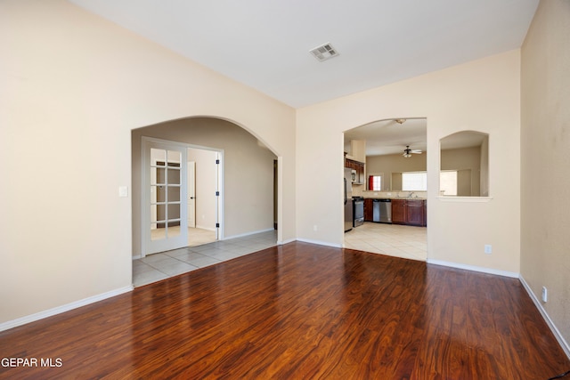 empty room featuring ceiling fan, sink, and light hardwood / wood-style flooring