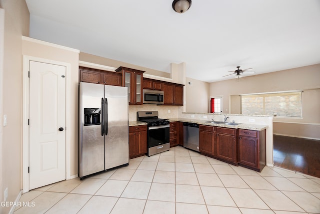 kitchen with decorative backsplash, ceiling fan, sink, stainless steel appliances, and light tile patterned floors