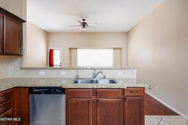 kitchen with light wood-type flooring, decorative backsplash, stainless steel dishwasher, sink, and kitchen peninsula