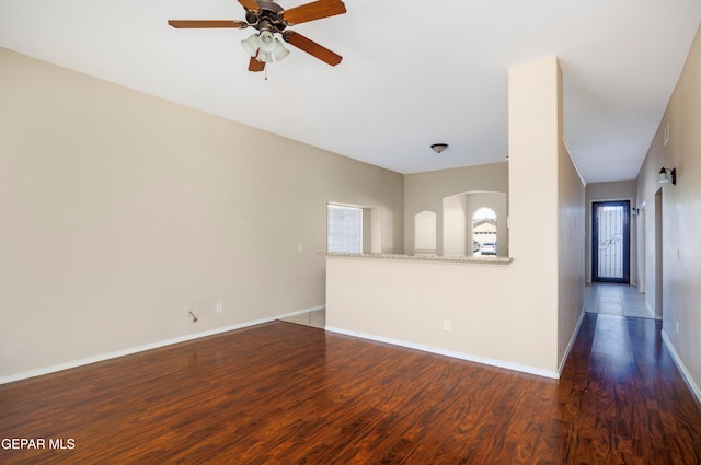 empty room featuring dark hardwood / wood-style flooring and ceiling fan