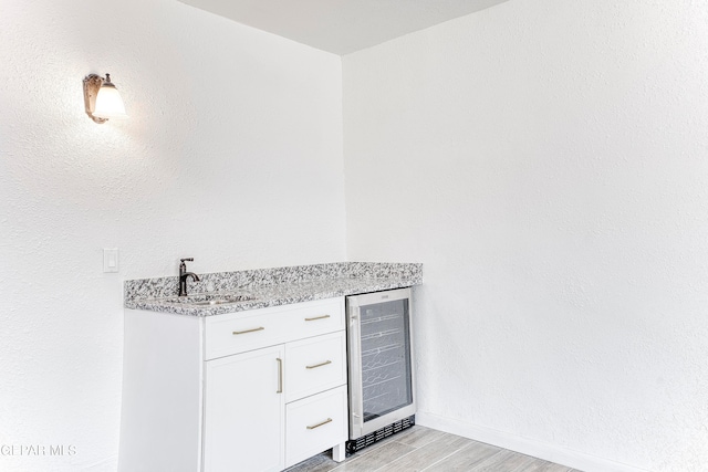 bathroom featuring hardwood / wood-style floors, beverage cooler, and sink