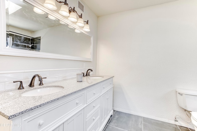 bathroom featuring tile patterned flooring, vanity, and toilet