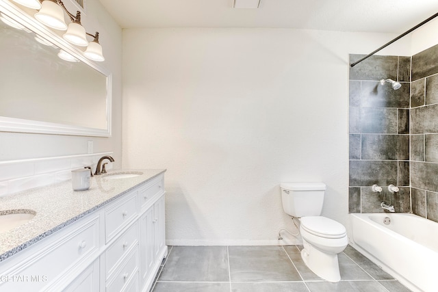 full bathroom with tiled shower / bath, tile patterned floors, vanity, and toilet