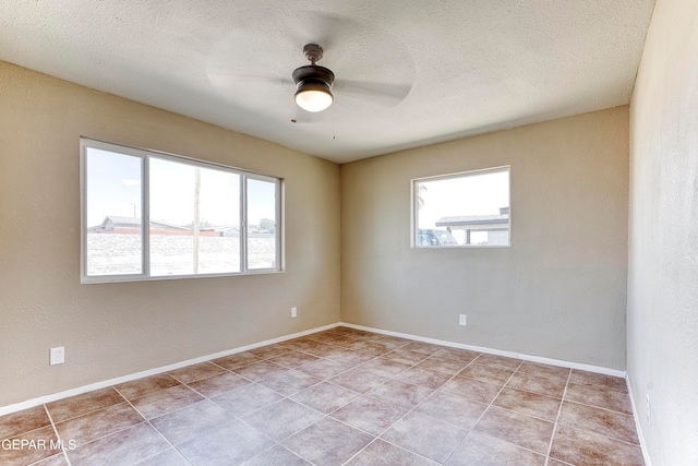 tiled empty room featuring a textured ceiling and ceiling fan