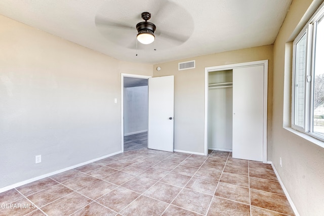 unfurnished bedroom featuring a closet, light tile patterned floors, and ceiling fan