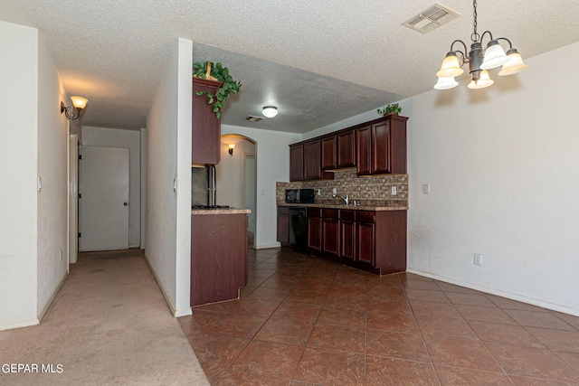 kitchen with dark tile patterned floors, a textured ceiling, sink, pendant lighting, and backsplash