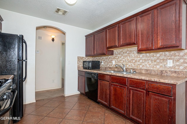 kitchen featuring tile patterned flooring, sink, backsplash, black appliances, and a textured ceiling