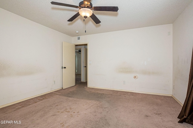 carpeted empty room with ceiling fan and a textured ceiling