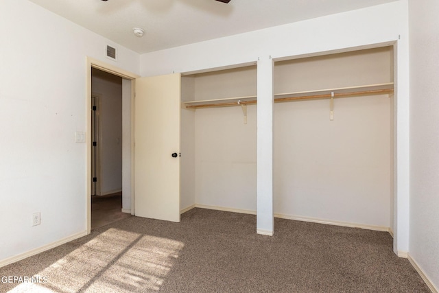 unfurnished bedroom with ceiling fan, two closets, and carpet