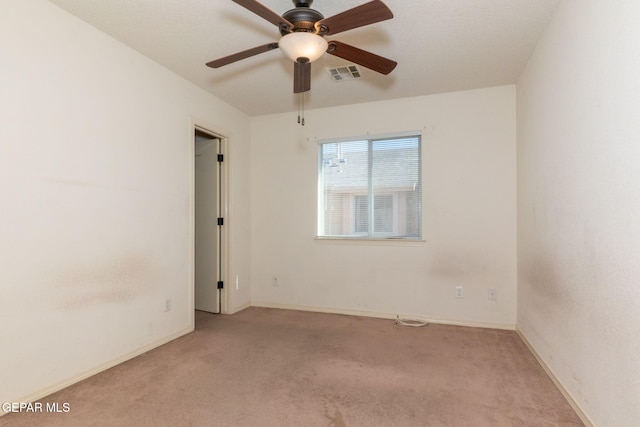 carpeted spare room featuring ceiling fan