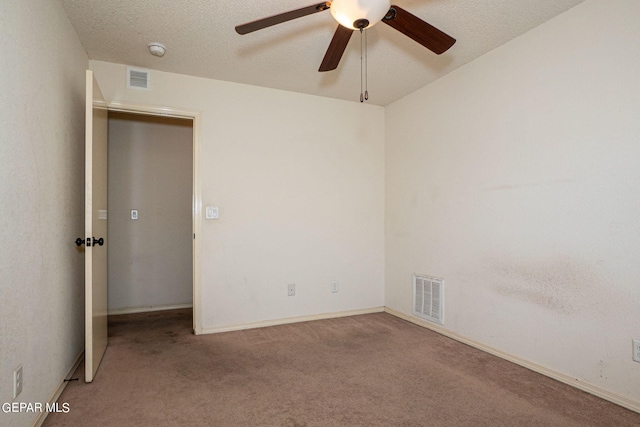 unfurnished room with ceiling fan, a textured ceiling, and light carpet