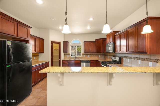 kitchen featuring pendant lighting, a breakfast bar area, stainless steel appliances, and kitchen peninsula