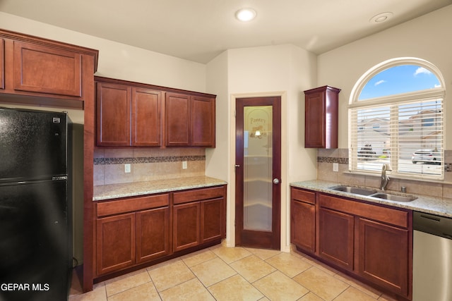 kitchen with black fridge, plenty of natural light, sink, and dishwasher