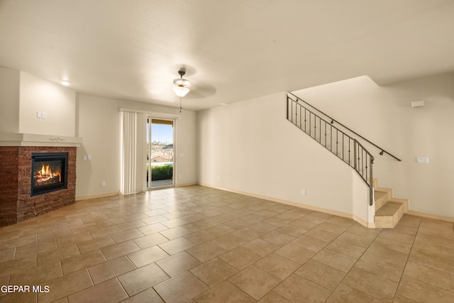 unfurnished living room with ceiling fan, light tile patterned flooring, and a tiled fireplace