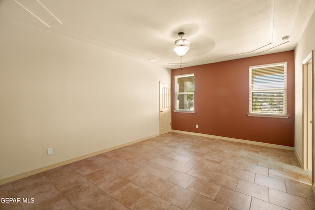 tiled empty room featuring ceiling fan