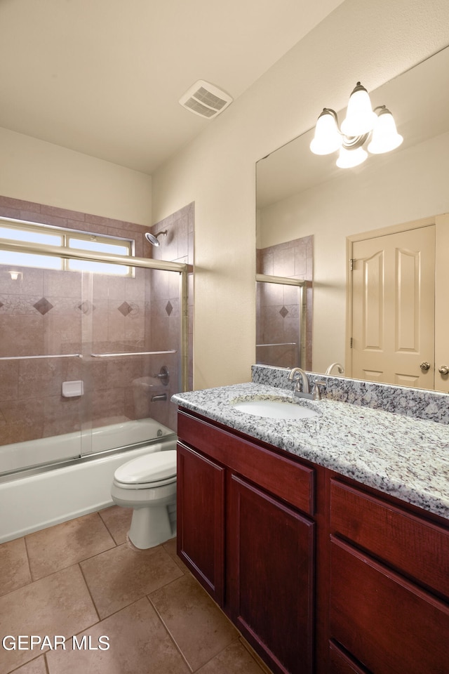 full bathroom featuring vanity, tile patterned floors, toilet, and combined bath / shower with glass door