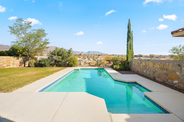 view of swimming pool with a mountain view, a yard, and a patio area