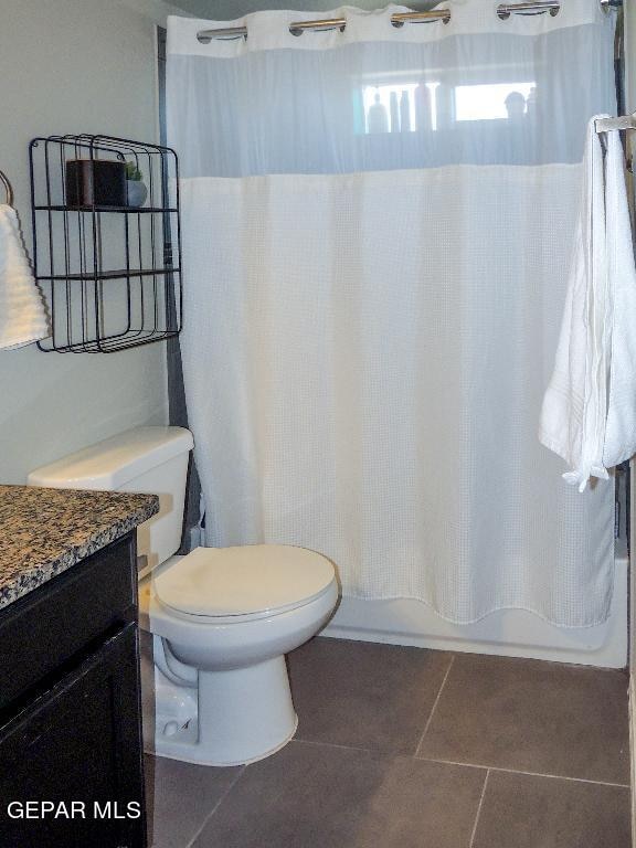 full bathroom with vanity, shower / bath combo, toilet, and tile patterned flooring