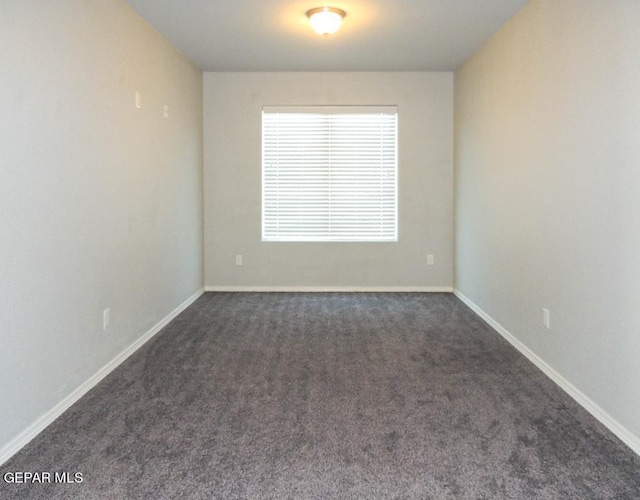 unfurnished room with dark carpet