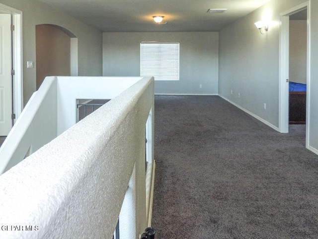 hallway with dark colored carpet