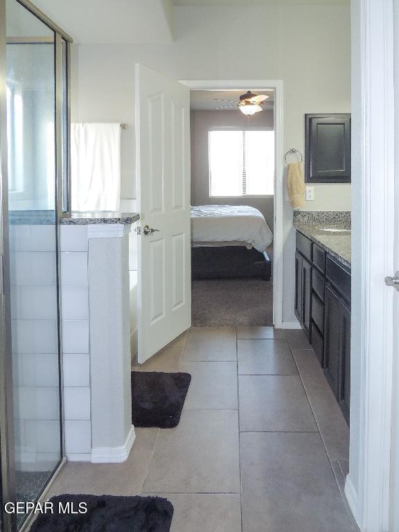 bathroom featuring vanity, walk in shower, tile patterned floors, and ceiling fan