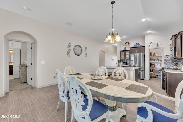 dining area with vaulted ceiling and a chandelier