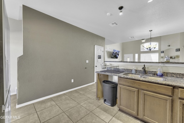 14241 Craggy Rock Ave, El Paso, TX 79938 - kitchen featuring dark stone countertops, light tile patterned floors, a sink, visible vents, and a chandelier