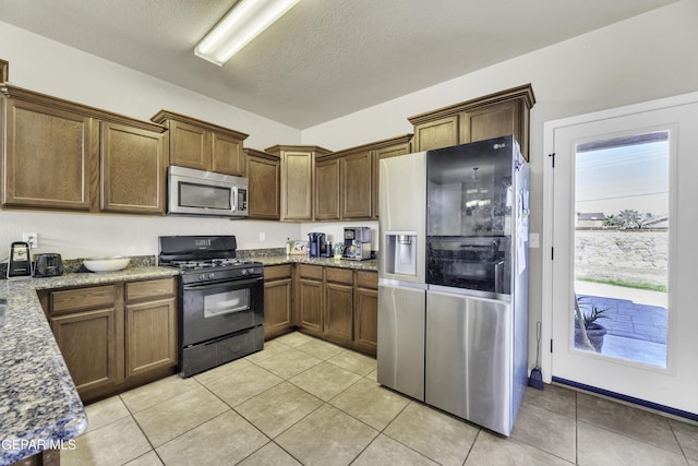 14241 Craggy Rock Ave, El Paso, TX 79938 - kitchen featuring appliances with stainless steel finishes, light tile patterned floors, and light stone countertops