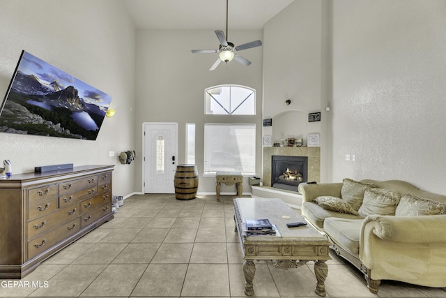 14241 Craggy Rock Ave, El Paso, TX 79938 - living room featuring a tile fireplace, light tile patterned floors, ceiling fan, baseboards, and a high ceiling