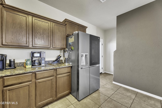 14241 Craggy Rock Ave, El Paso, TX 79938 - kitchen featuring stainless steel refrigerator with ice dispenser, light tile patterned flooring, and light stone counters