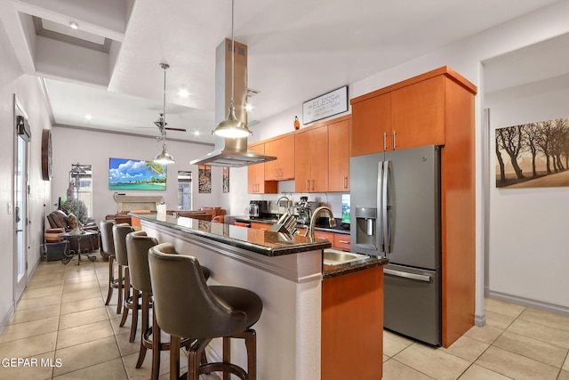 kitchen featuring a breakfast bar, sink, stainless steel fridge with ice dispenser, decorative light fixtures, and light tile patterned floors