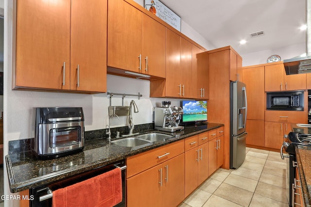 kitchen featuring sink, stainless steel refrigerator with ice dispenser, electric range, dark stone counters, and black microwave