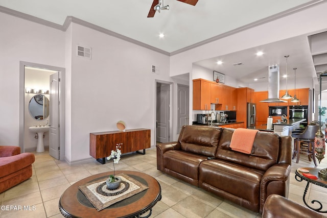 tiled living room with a towering ceiling, crown molding, sink, and ceiling fan