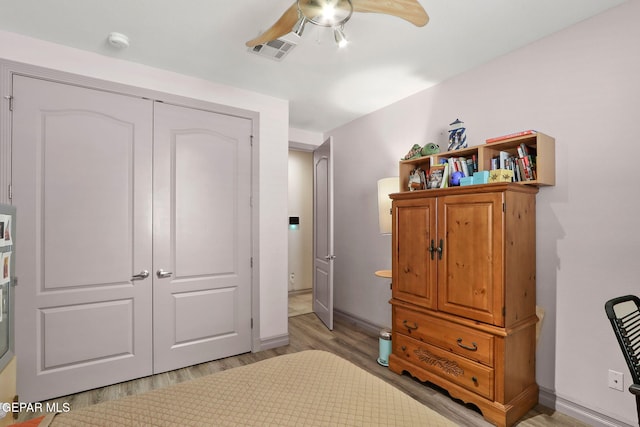 bedroom with ceiling fan, light hardwood / wood-style flooring, and a closet