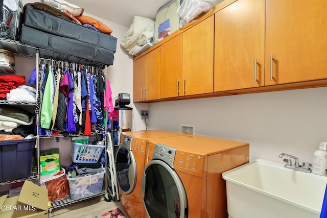 washroom featuring cabinets, sink, and washer and dryer