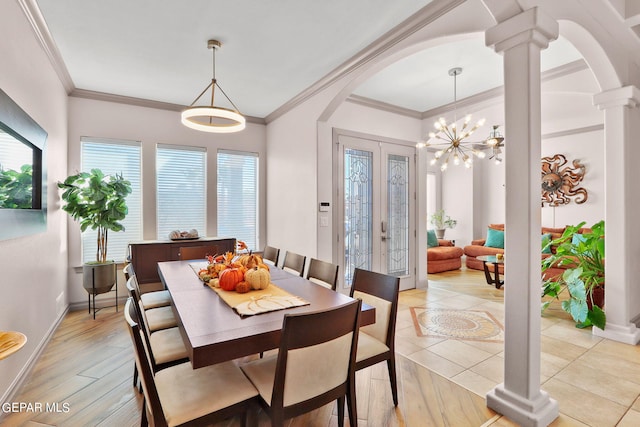 dining area with ornamental molding, an inviting chandelier, light wood-type flooring, and decorative columns