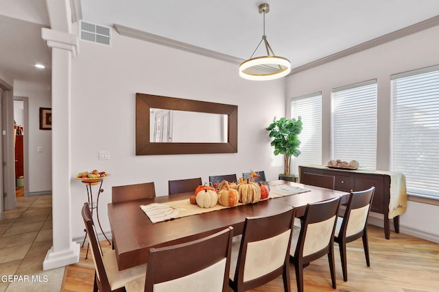 dining space with ornamental molding, light hardwood / wood-style flooring, and decorative columns