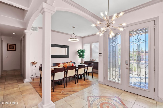 foyer featuring ornate columns, ornamental molding, light hardwood / wood-style flooring, and a wealth of natural light