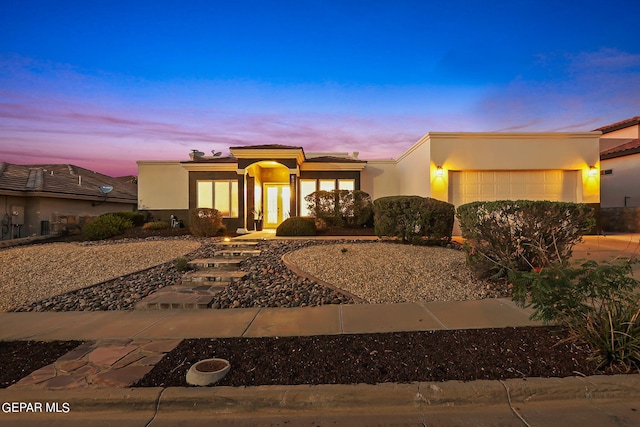 pueblo revival-style home featuring a garage