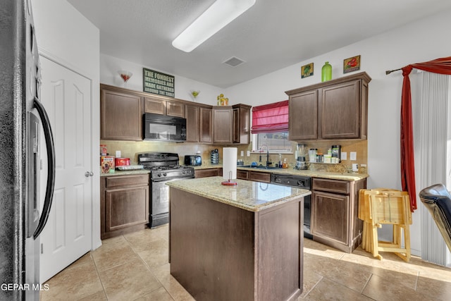 kitchen with a kitchen island, black appliances, dark brown cabinets, and sink