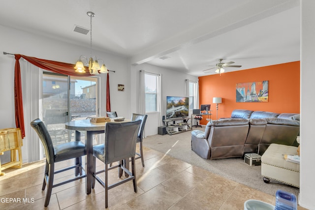 carpeted dining area with ceiling fan with notable chandelier