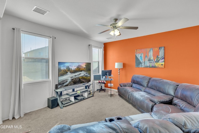 carpeted living room featuring ceiling fan and a healthy amount of sunlight