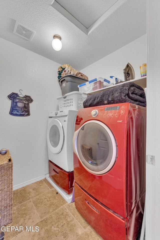 laundry room featuring washing machine and dryer and a textured ceiling